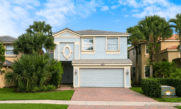 Two story home with two car garage and brick paver driveway at 9070 Dupont Place in Olympia, Wellington FL 33414
