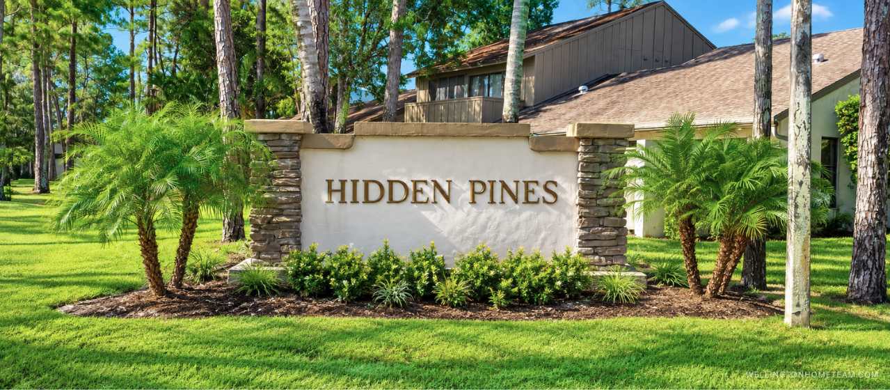 Hidden Pines community entrance sign surrounded by palm trees in Wellington, FL