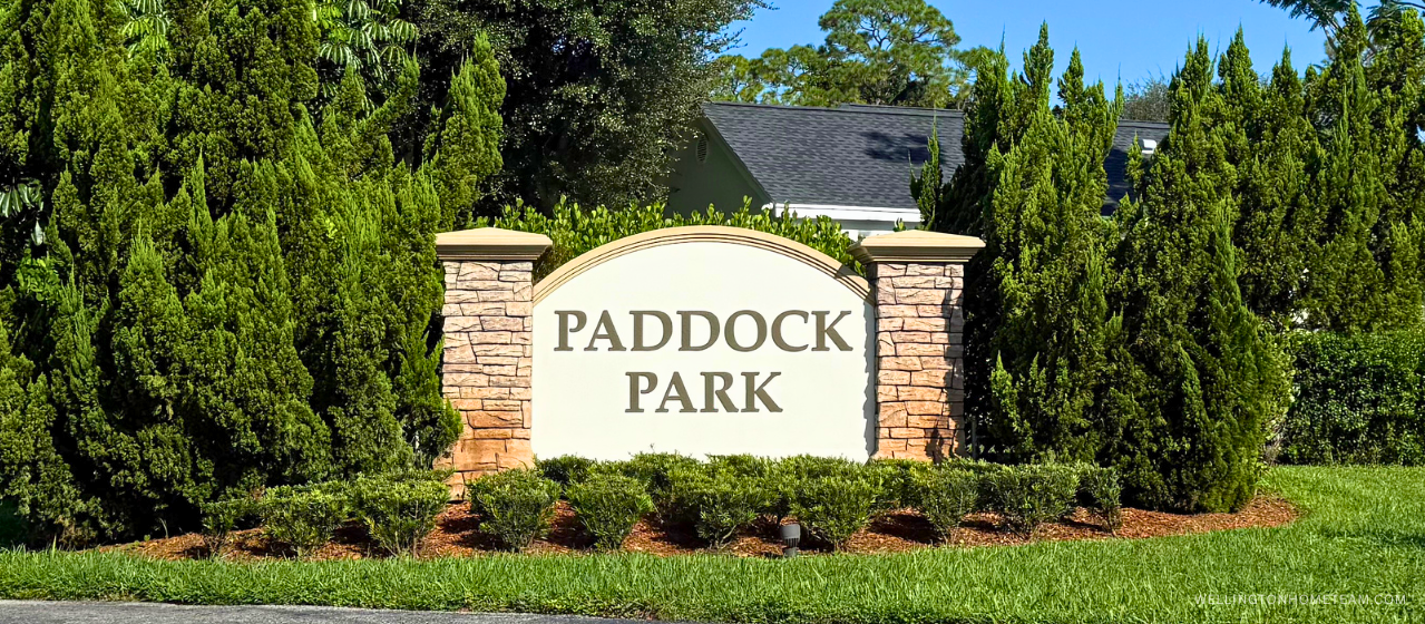 Paddock Park community entrance sign surrounded by palm trees in Wellington, FL